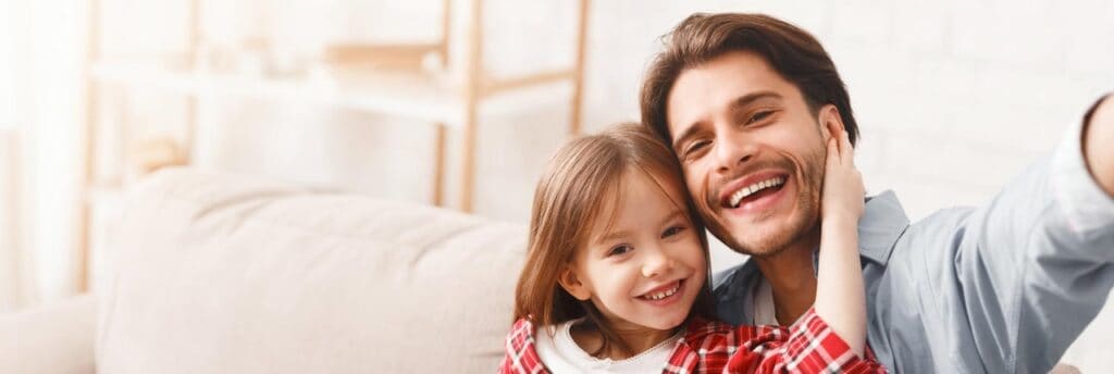 Padre e hija sonriendo en casa.